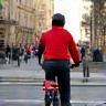 Coursier à vélo livrant une enveloppe dans le centre-ville de Lyon